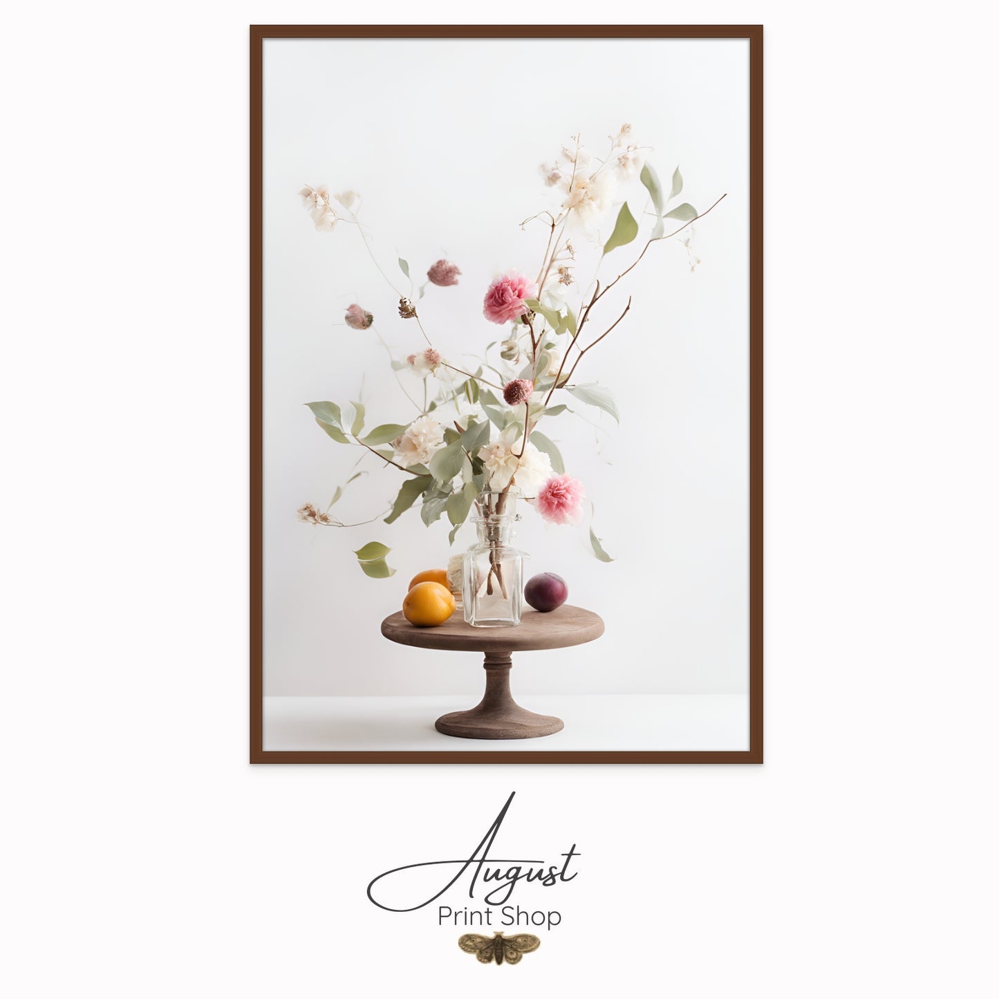 A light and pretty photo of a delicate flower bouquet featuring pink roses, soft green leaves and brown twigs. The bouquet sits on a wooden stand with a lemon and plum.