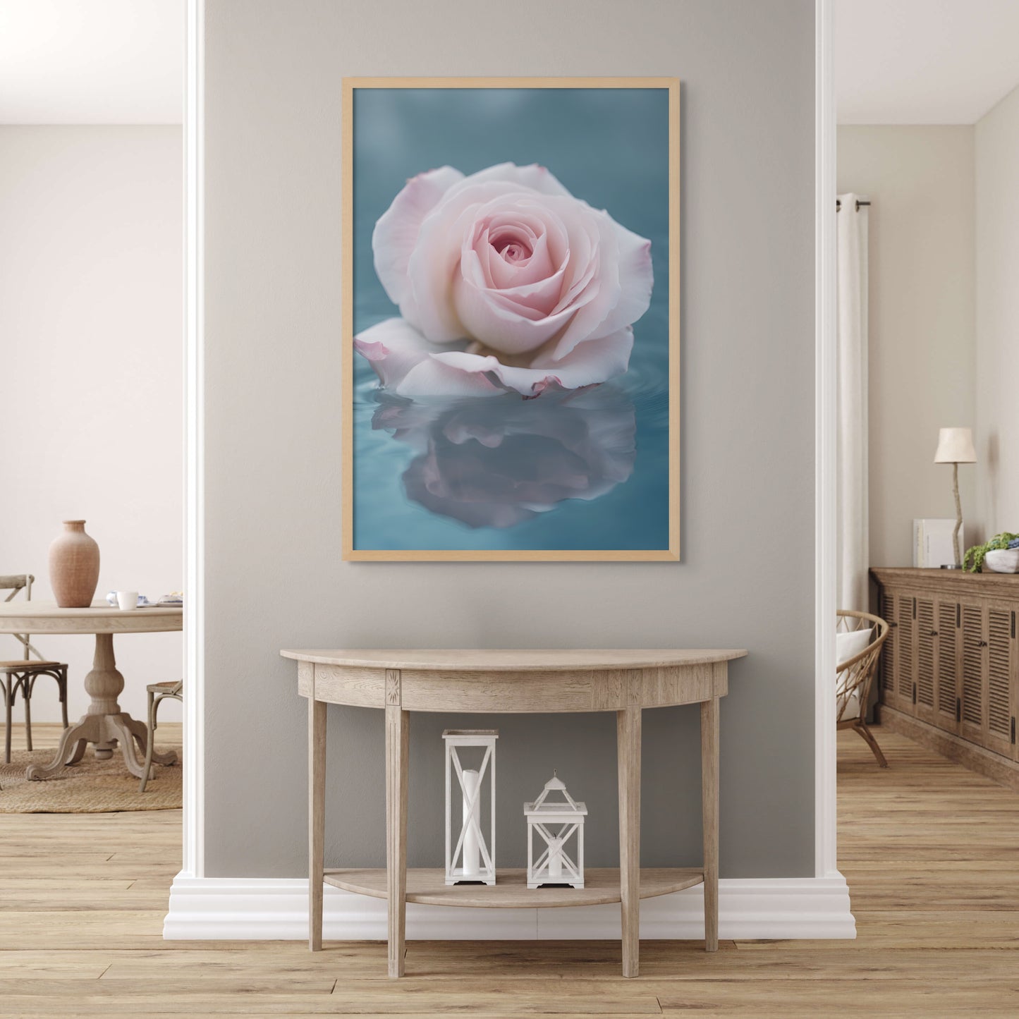 A unique photograph of a soft pink rose floating in soft blue water. It's reflection can be seen in the serene water. Displayed on a light grey wall in a hall.