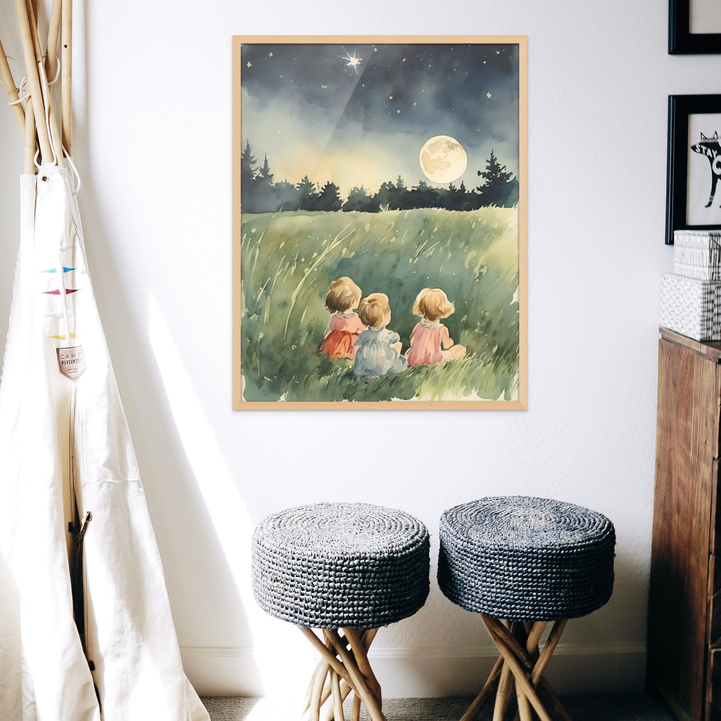Three children sit in a field and watch the full moon and the stars on a clear summer night. Done as a watercolor style painting. Displayed in a childs room above two grey benches.