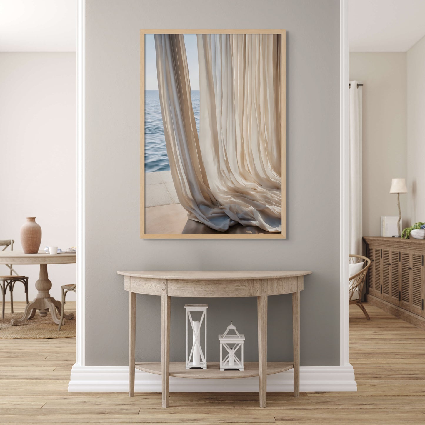 Print on canvas framed in a natural wood frame of Light and sheer linen beige curtains flow on the floor next to a window that over looks the ocean. Displayed above a wooden hutch on a grey wall.