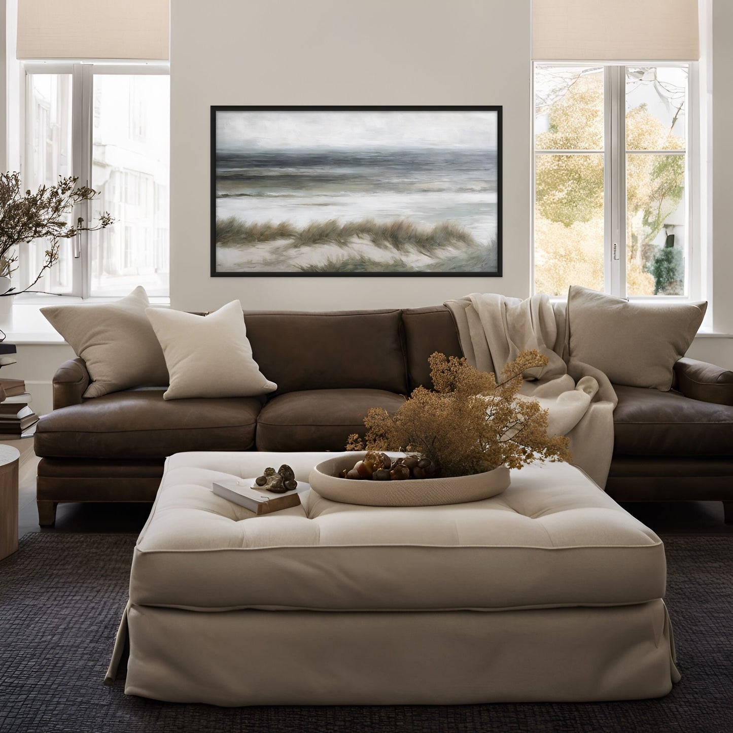 Beach grass artwork displayed above a brown couch and a white ottoman