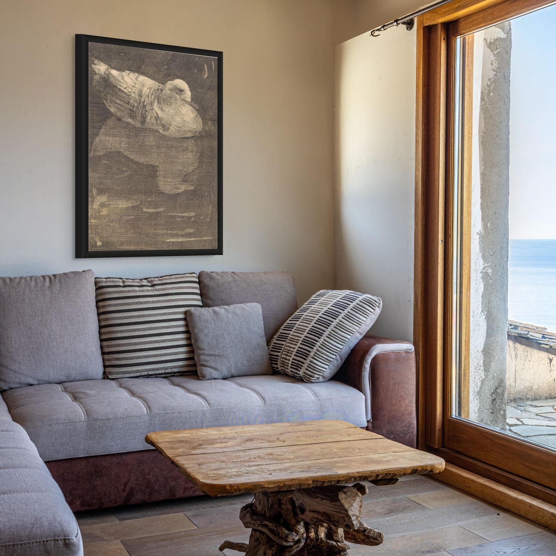 Living room with gray sofa, wooden coffee table, and large window with scenic view.