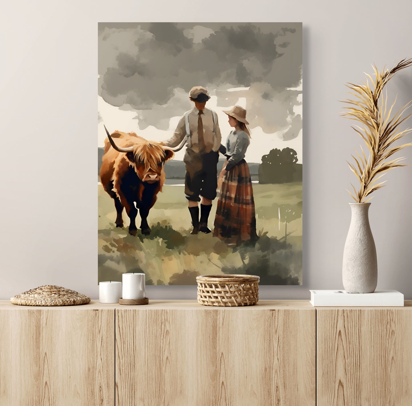 A Scottish styled couple stand in a field next to their highland cow done as a Print on Canvas. Styled above a light wood hutch.