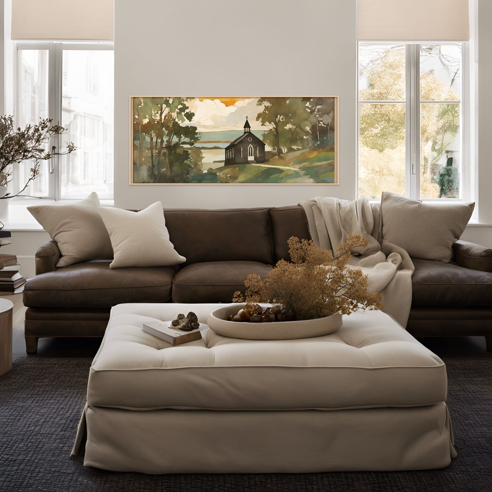 black church artwork above a dark brown leather couch and white ottoman