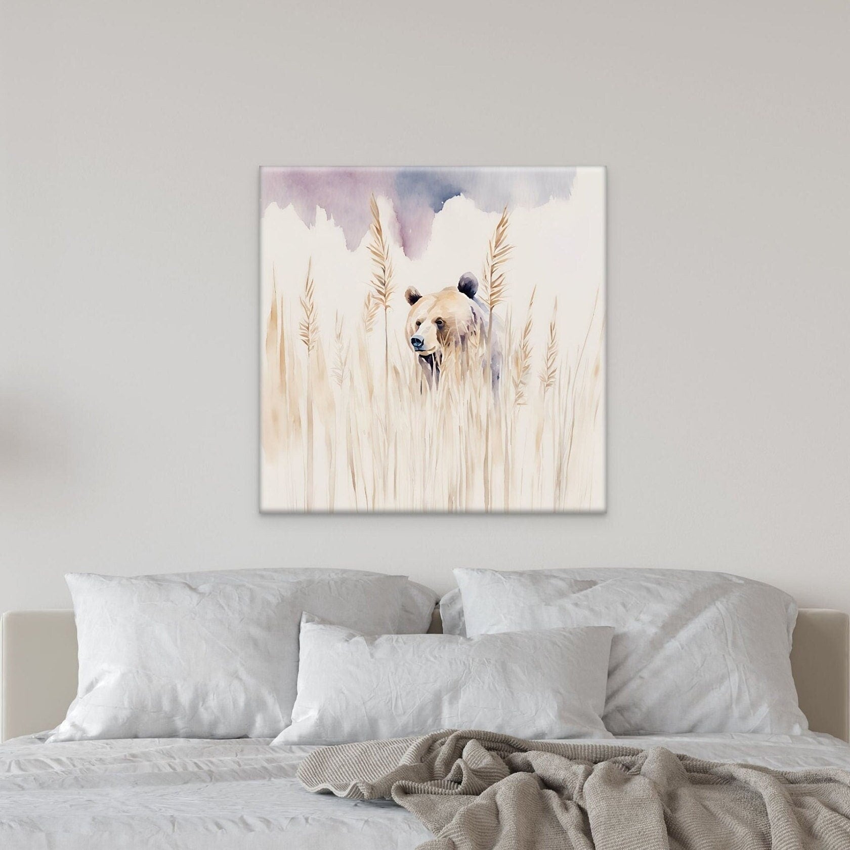 Wall art watercolor of a brown bear peeking out of a field. Artwork displayed above a white bed